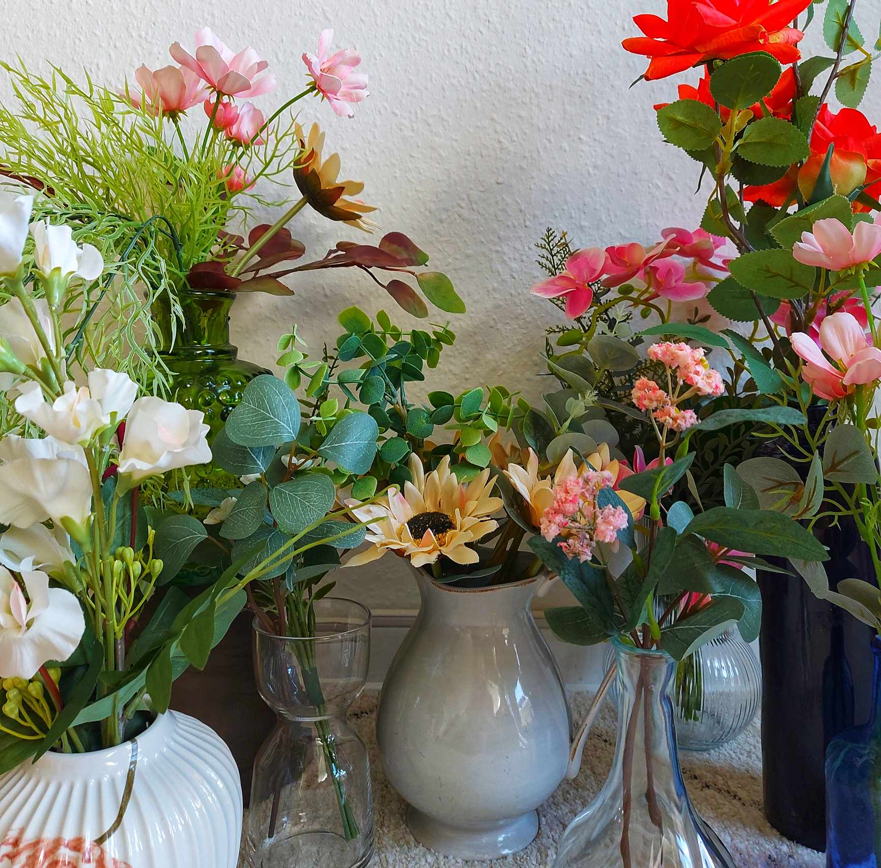 mange blomster i vaser